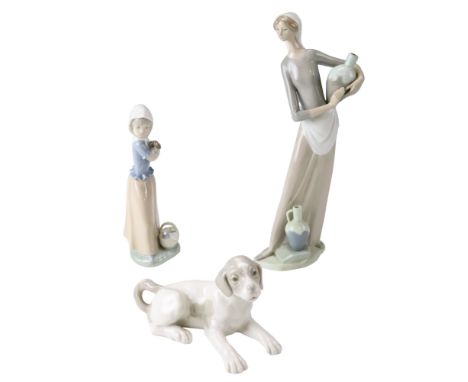 Three Nao figurines comprising a water carrier, a girl and puppy and a dog, tallest 33 cm