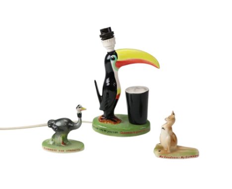 A reproduction Guinness toucan ceramic table lamp together with two reproduction figurines, lamp 10.5 cm to socket