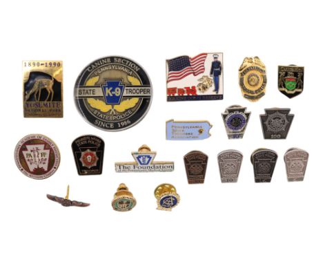 A group of North American collar and lapel badges including Pennsylvania State Police, Marine Corps Reserve, Yosemite Nationa