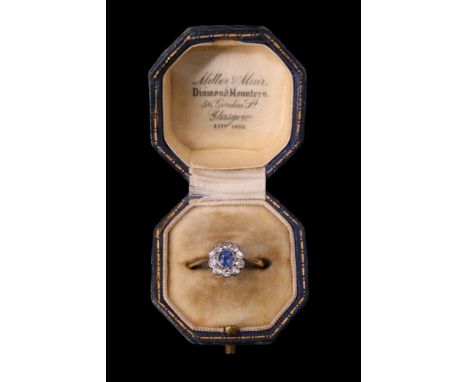 An antique sapphire and diamond "daisy" ring, comprising a round cut sapphire of approx 33 ct millegrain-set within a ring of