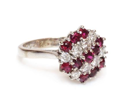 A ruby and diamond hexagonal cluster ring, c.1970, with alternating rows of brilliant cut diamonds, between rows of circular 