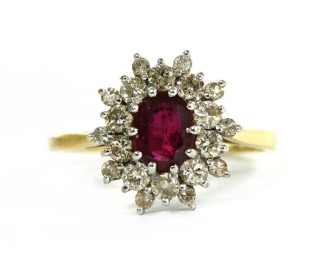 An 18ct gold ruby and diamond cluster ring, with an oval mixed cut ruby, approximately 7.0 x 5.3mm, claw set, to surround of 