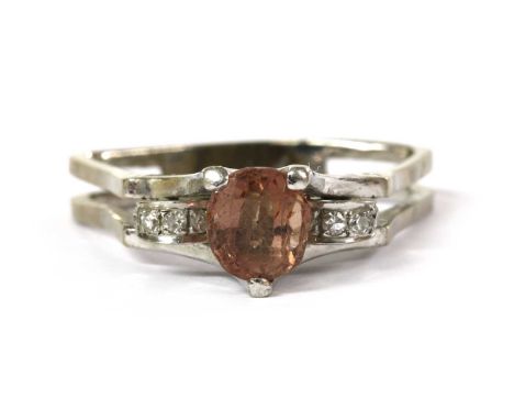 A white gold gemset and diamond ring, with a mixed cut orangey brown gemstone, possibly hessonite garnet, to arched shoulders