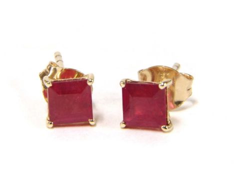 A pair of gold single stone fracture filled ruby stud earrings, with a square step cut fracture filled ruby, approximately 5m