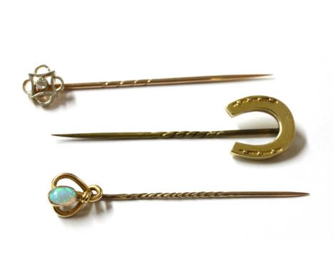 Three gold stick pins, to include a horseshoe stick pin, tested as approximately 9ct gold with metal pin, an opal stick pin, 