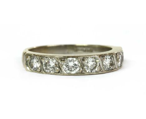 An 18ct white gold seven stone diamond ring, with a row of brilliant cut diamonds, grain set, to a plain tapered shank, Londo