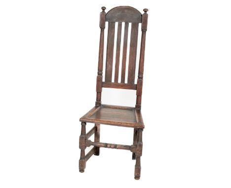 An 18th Century oak high back Side Chair, the latted back with dome top and finial mounts, above a recessed seat on turned fr