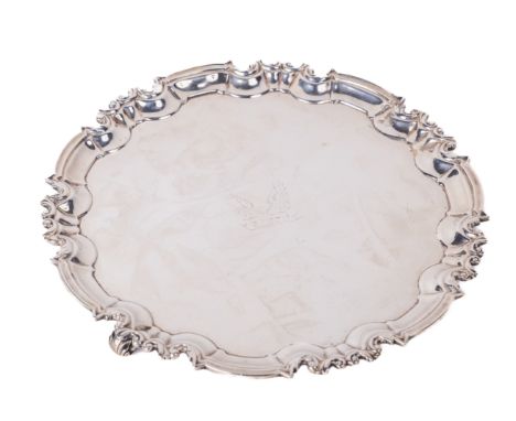 An attractive Georgian style circular three legged Salver or Waiter, the moulded and shaped rim with an unusual crested centr
