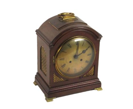 A late 19th Century mahogany Bracket or Mantle Clock, the arched top with brass carrying handle, over a circular brass dial w
