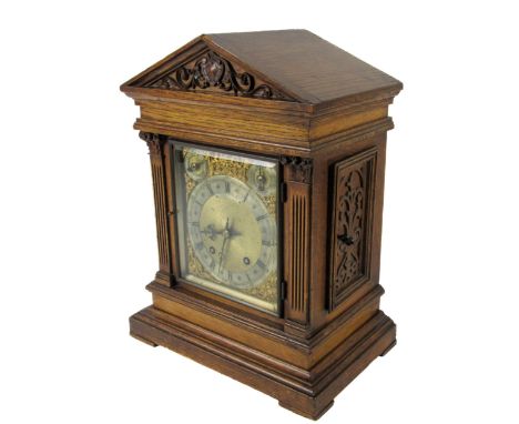 An oak cased 20th Century German made brass and steel dial Bracket Clock, the arched hood over glazed door, pierced decorated