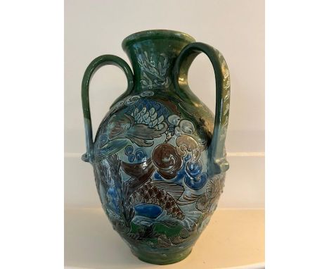 A CH Brannam art pottery three handled vase. An earthenware vase decorated in relief design. the base of the vase signed Ch B