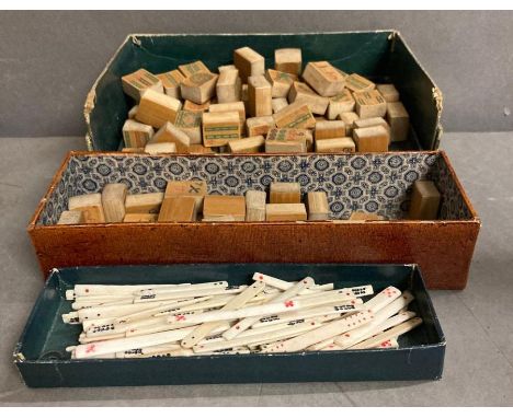 A selection of wooden mahjong pieces along with a volume of bone and some plastic betting sticks 