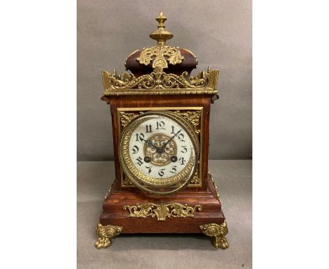 An eight day enamel faced mantel clock on brass lion paw feet 