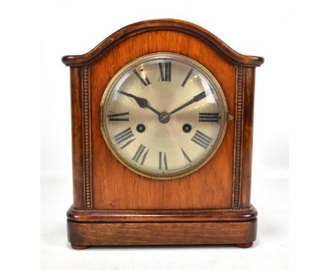 An early 20th century mahogany cased mantel clock, the silvered circular dial set with Roman numerals, with beaded detail on 