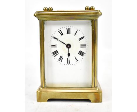 A brass cased carriage clock, the circular dial set with Roman numerals, height excluding swing handle 10.8cm, cased.Addition