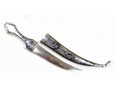 An Iraqi white metal and niello enamel decorated dagger with curved steel blade in scabbard inscribed 'N.R.G.' to reverse, le