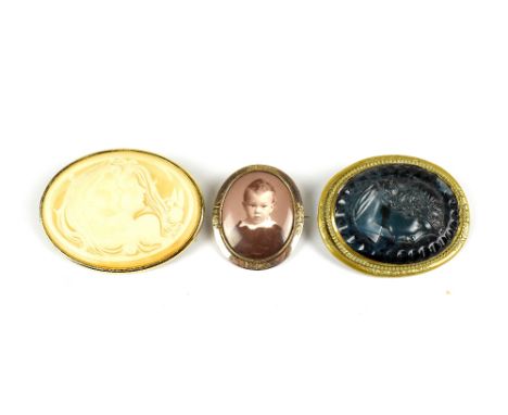 A Victorian blue glass cameo brooch, decorated in relief with a portrait bust inside a gilt metal mount, with two further bro