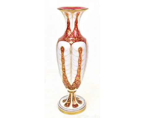 A large 19th century Bohemian ruby glass baluster vase featuring opaque white enamel and gilt floral scroll decoration, with 