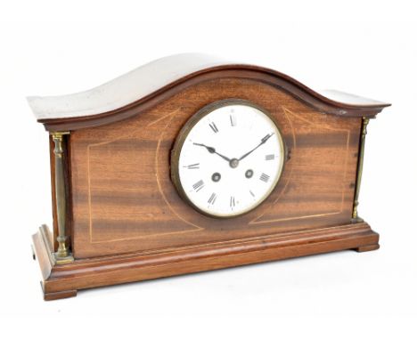 An Edwardian inlaid mahogany arch topped mantel clock, the enamel dial with Roman numerals, raised on bracket feet, height 22