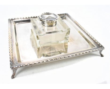 BARKER BROTHERS; a George V hallmarked silver mounted glass inkwell on square section stand to four feet, Chester 1922, stand