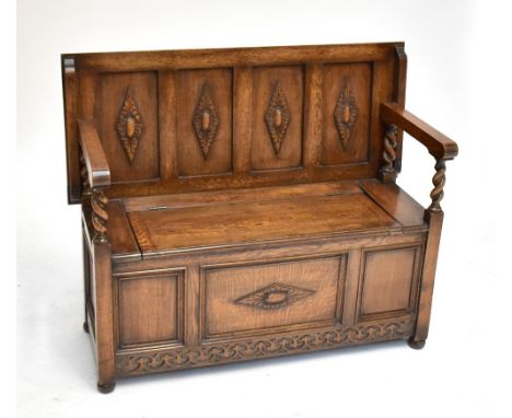 A 1920s/30s oak monk's bench, with carved and panelled decoration, length 114cm.