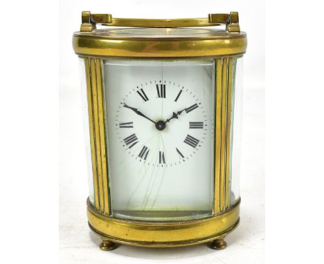 A late 19th/early 20th century French brass cased carriage clock of oval form, the white enamelled dial set with Roman numera