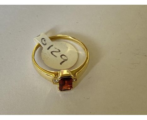 A 9 CARAT YELLOW GOLD RING WITH CENTRE EMERALD CUT GARNET AND TWO DIAMONDS. WEIGHT 1.7 GRAMS, RING SIZE N. WITH GIE CERTIFICA