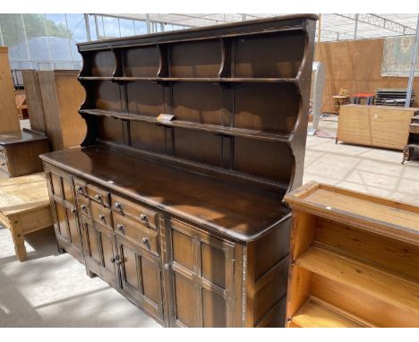 A LARGE ERCOL ELM DRESSER WITH FOUR DOORS, FOUR DRAWERS AND UPPER PLATE RACK 