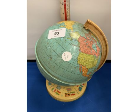 A VINTAGE TIN GLOBE 8 INCHES HIGH WITH A STAND DISPLAYING FLAGS OF THE WORLD 