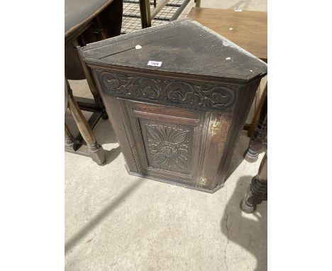 AN OAK FLAT FRONT CORNER CUPBOARD WITH CARVED PANEL DOOR 