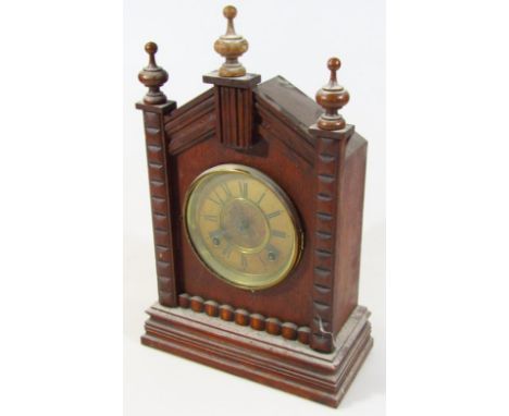 An early 20thC Ansonia oak cased mantel clock, in the Gothic style with triangular pedimented case surmounted by three urn fi