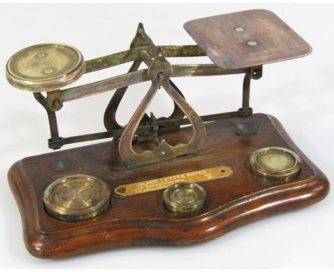 An early 20thC Inland Letter Rates table postal scale, on a serpentine oak base, with articulated metal pans and three weight