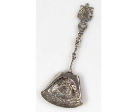 A Dutch caddy spoon, with a part pierced floral stem, headed by a milk maid with repoussé bowl, decorated with figure in a bo
