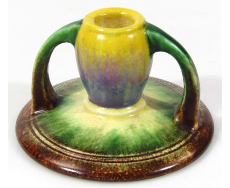 An early 20thC Bretby candlestick, number 3182, splash decorated with moulded handles, on circular foot, impressed marks bene