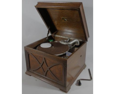 A mid 20thC oak cased gramophone, the domed lid hinging to reveal an articulated interior with chrome plated arm and baize ty