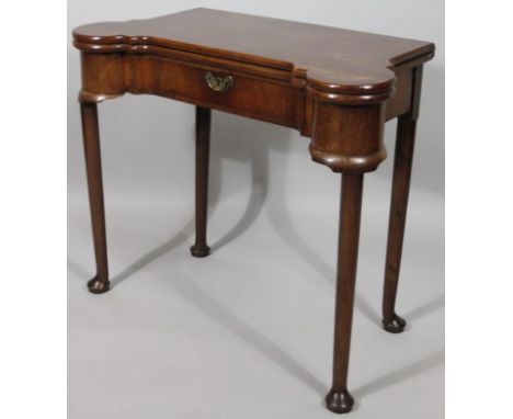 A George III mahogany fold over games table, with concertina action in the Chippendale style, the shaped top hinging to revea