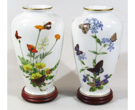 A pair of Franklin porcelain John Wilkinson vases, the Alpine Butterfly Vase and Meadowland Butterfly Vase, each on wooden st