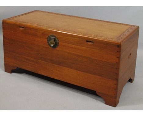 A 20thC light camphor wood chest, the hinged lid with an outer carved floral banding, opening to reveal a part fitted interio