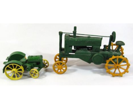 A 20thC metal John Deere classic tractor, in green with yellow articulated wheels, 17cm wide, and another, bigger and later. 
