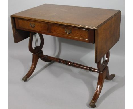 A mid 20thC walnut finish drop leaf sofa table, the overhanging moulded top with a wide cross banding above two real and two 