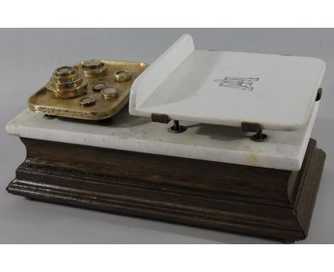 An early 20thC Avery table scale, on an oak base with marble stand and ceramic and brass plates, 53cm wide, and various brass