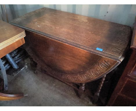 An early 20th century oak carved, gateleg table with barley twist supports, together wit a reproduction fold over card table,