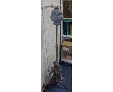 A late Victorian cast metal standard lamp converted from an oil lamp having an adjustable column and scrolled legs, 161cm hLo