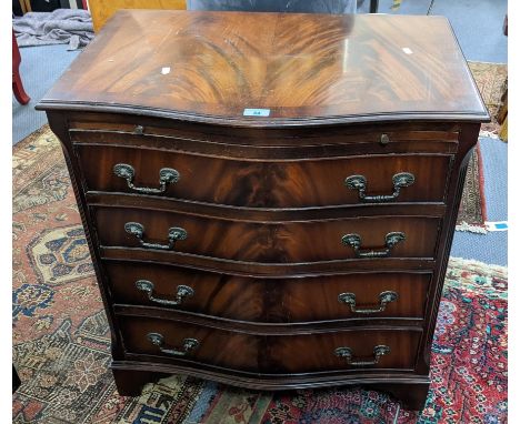 A late 20th century mahogany finished, serpentine fronted chest with a brushing slide and four long drawers on bracket feet, 