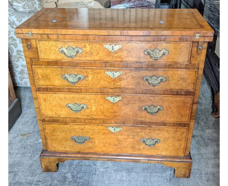 A reproduction burr walnut gentleman's dressing chest having a fold over top above four graduated drawers and bracket shaped 