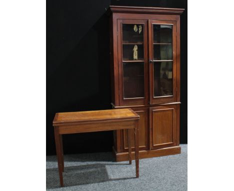 A Victorian design mahogany library bookcase, outswept cornice above a pair of glazed doors enclosing two adjustable shelves,