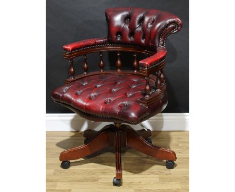 A Victorian style swivel desk or 'captain's' chair, stuffed-over deep button oxblood upholstery, 87cm high, 64cm wide, the se