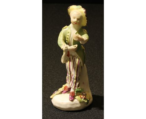 A Derby Patch Mark figure, of a boy, wearing a yellow hat, green waistcoat, and striped trousers, 12.5cm high, c.1765 