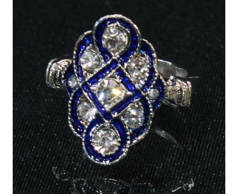 An Art Deco style base metal kite shaped dress ring, set with clear glass and blue enamel, ring size K, boxed 