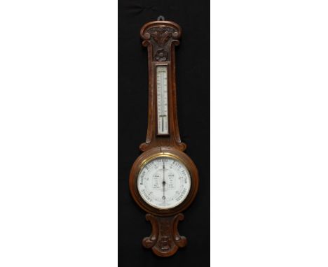A late Victorian oak aneroid wheel barometer, 19cm circular register inscribed Admiral Fitzroy's Indications, the case carved